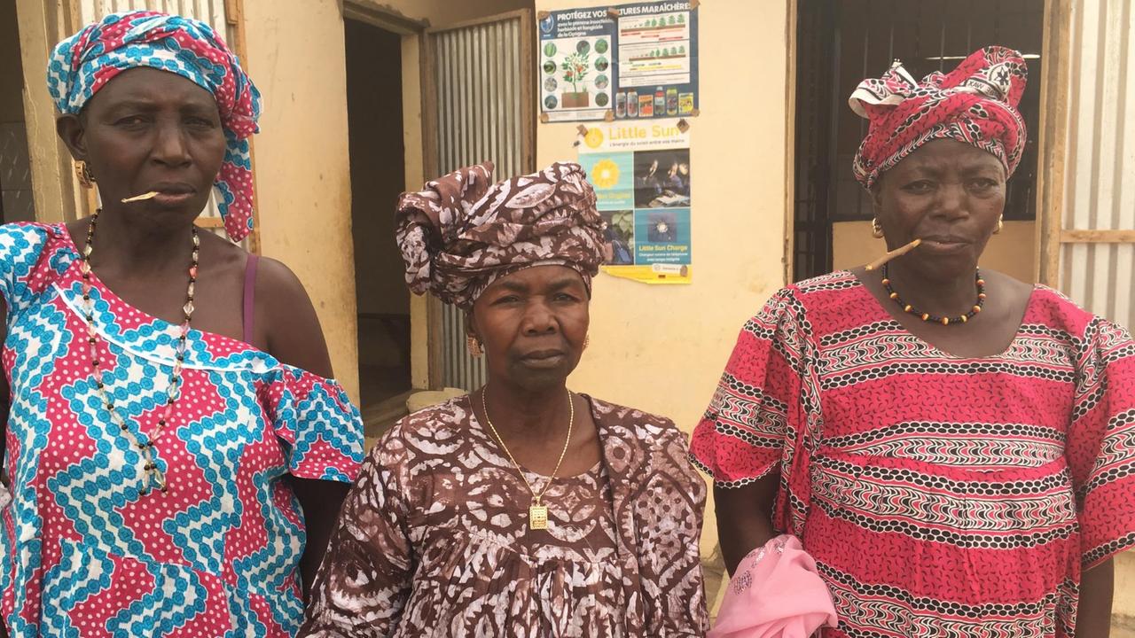 Mama Diouf, Chefin der Frauenkooperative in der Mitte, mit zwei Kolleginnen