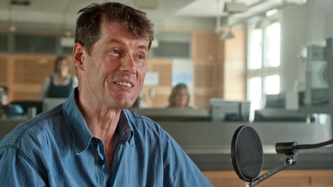 Der Dichter Uwe Kolbe sitzt in einem Radiostudio