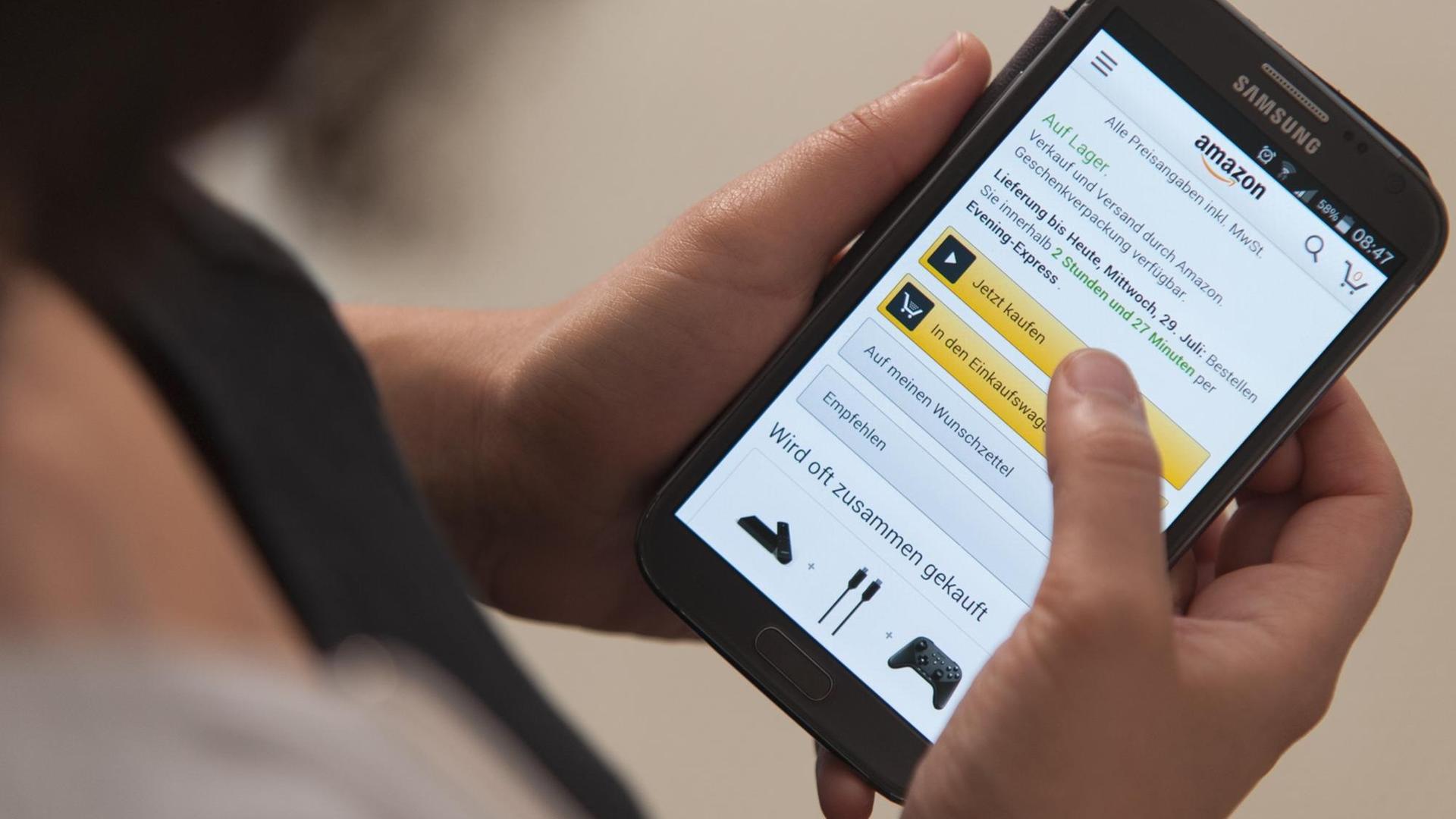 Eine Frau bedient die Smartphone-App von Amazon. Eine Frau bedient die Smartphone-App von Amazon.
