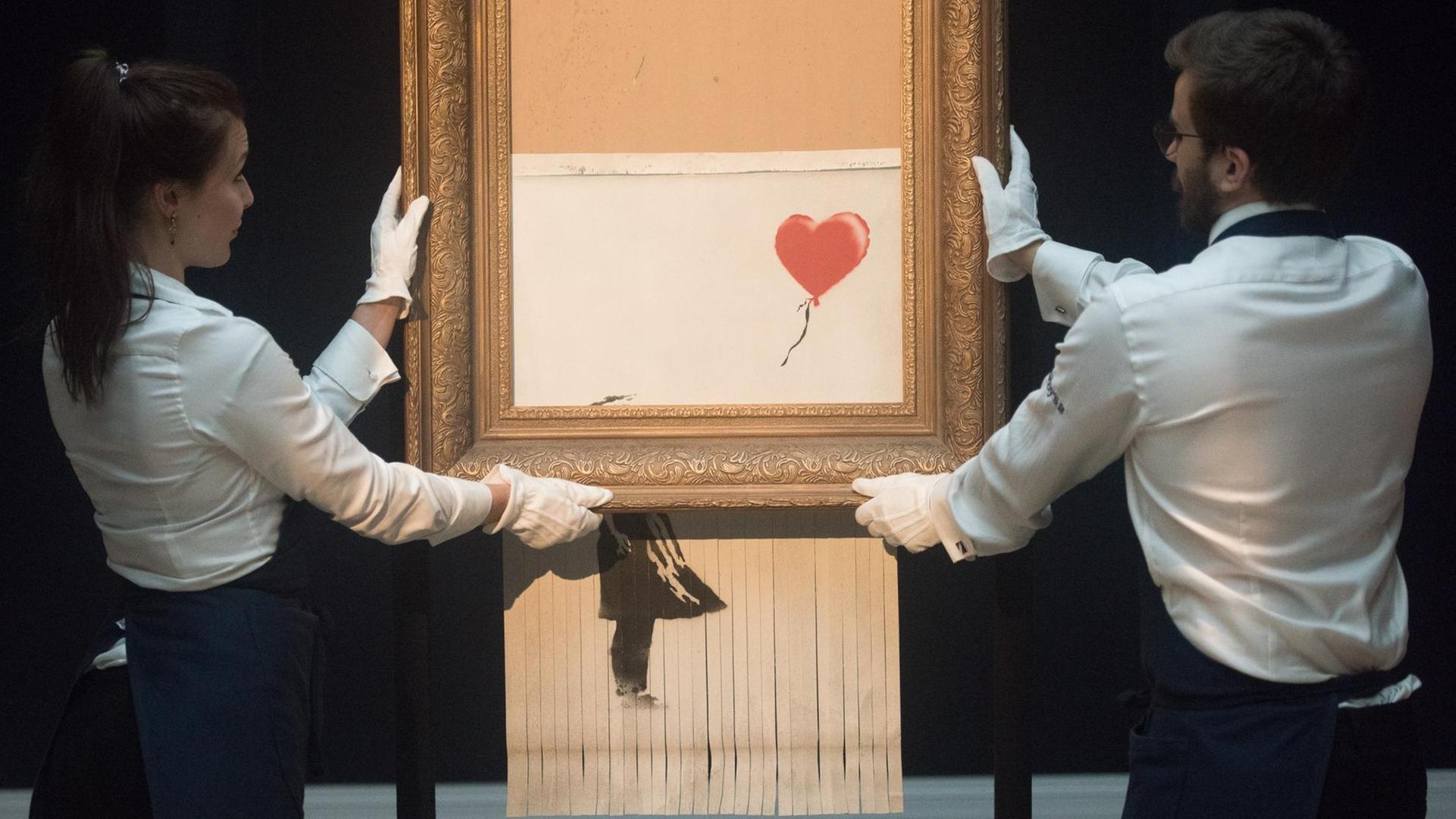 Das Auktionshaus Sotheby's präsentiert das zerstörte Banksy-Bild "Girl With Balloon, 2018". Das Auktionshaus Sotheby's präsentiert das zerstörte Banksy-Bild "Girl With Balloon, 2018".