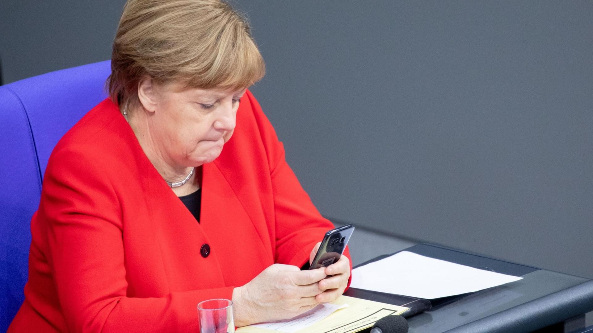 Angela Merkel am Handy im Bundestag