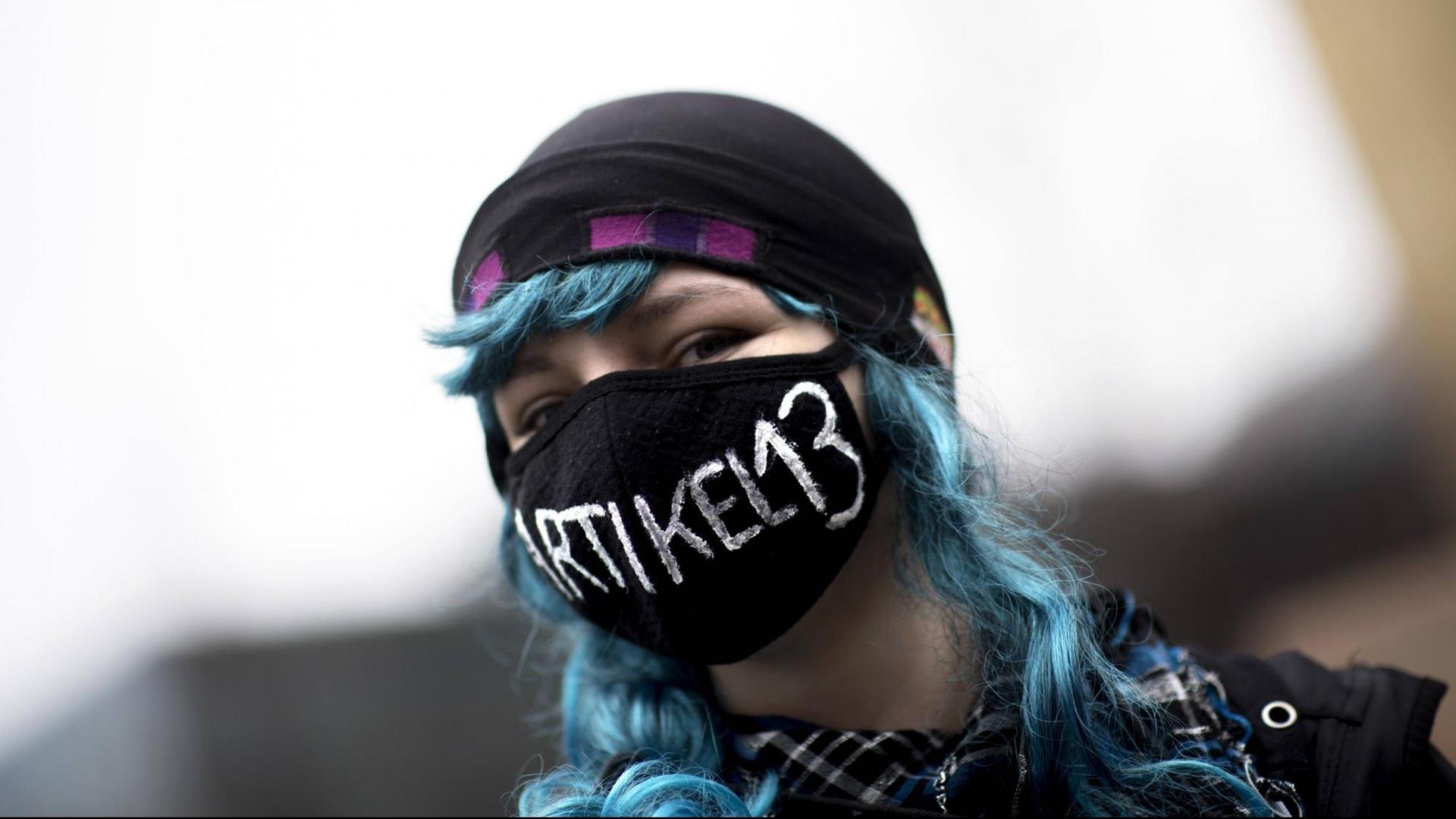 Eine junge Demonstrantin protestiert in Berlin gegen die EU-Urheberrechtsreform. Sie trägt einen Mundschutz, auf dem "Artikel 13" steht. Eine junge Demonstrantin protestiert in Berlin gegen die EU-Urheberrechtsreform. Sie trägt einen Mundschutz, auf dem "Artikel 13" steht.