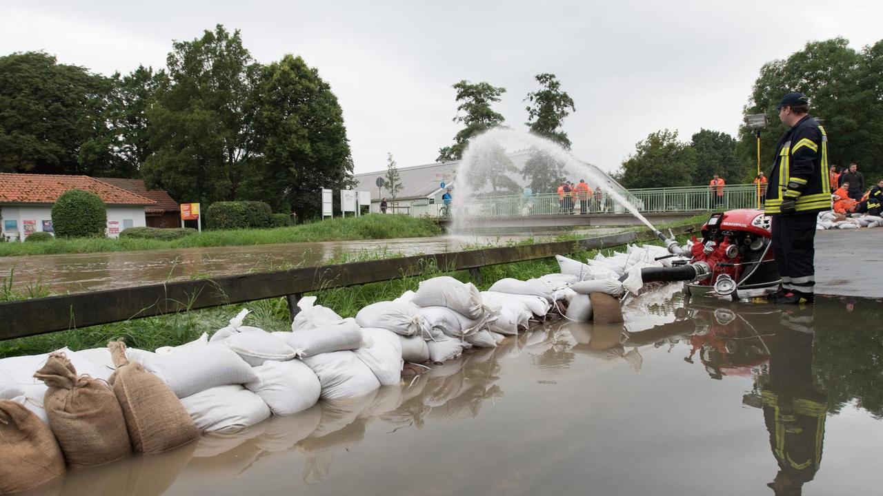Sandsäcke liegen am 27.07.2017 in Hildesheim (Niedersachsen) vor dem Fluss Innerste. Dauerregen hat im südlichen Niedersachsen in einigen Orten zu Überschwemmungen geführt. Foto: Swen Pförtner/dpa | Verwendung weltweit