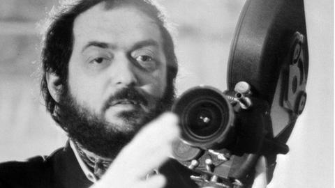 Der Regisseur Stanley Kubrick mit einer Filmkamera auf einem undatierten Foto.