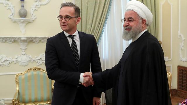 Auf dem Bild begrüßt Irans Präsident Hassan Ruhani Bundesaußenminister Heiko Maas mit Händedruck.