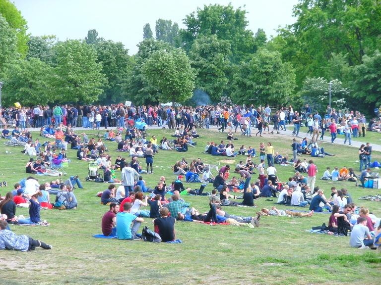 Menschen sitzen auf der Grünfläche vom Görlitzer Park.