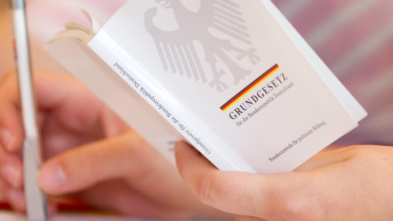 Eine Jura-Studentin hält in einer Vorlesung an der Universität Osnabrück (Niedersachsen) eine Ausgabe vom Grundgesetz in der Hand. 