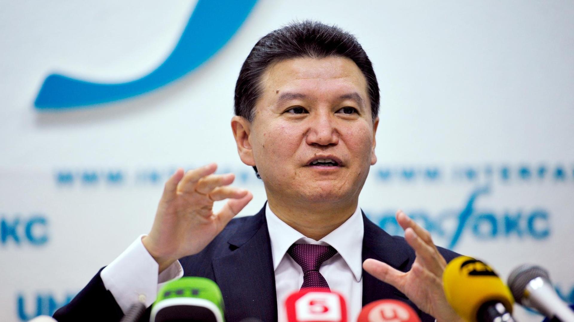 Der Präsident des Weltschachverbandes, Kirsan Iljumschinow, steht an einem Pult vor Mikrofonen.
