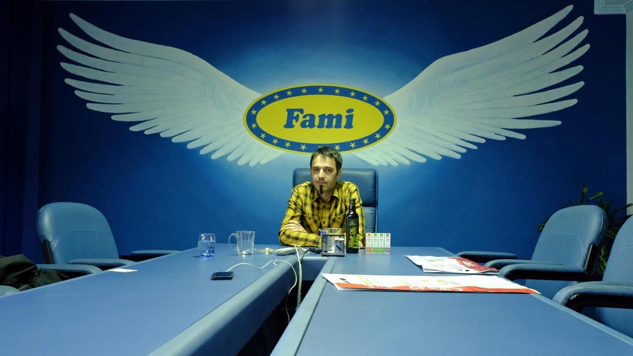 Mladen Falamić im blauen Konferenzraum, hinter sich das geflügelte Logo des Familienbetriebs "Fami"