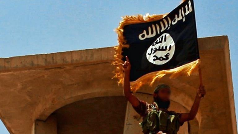 Ein Anhänger des IS mit der Flagge der Miliz Ein Anhänger des IS mit der Flagge der Miliz