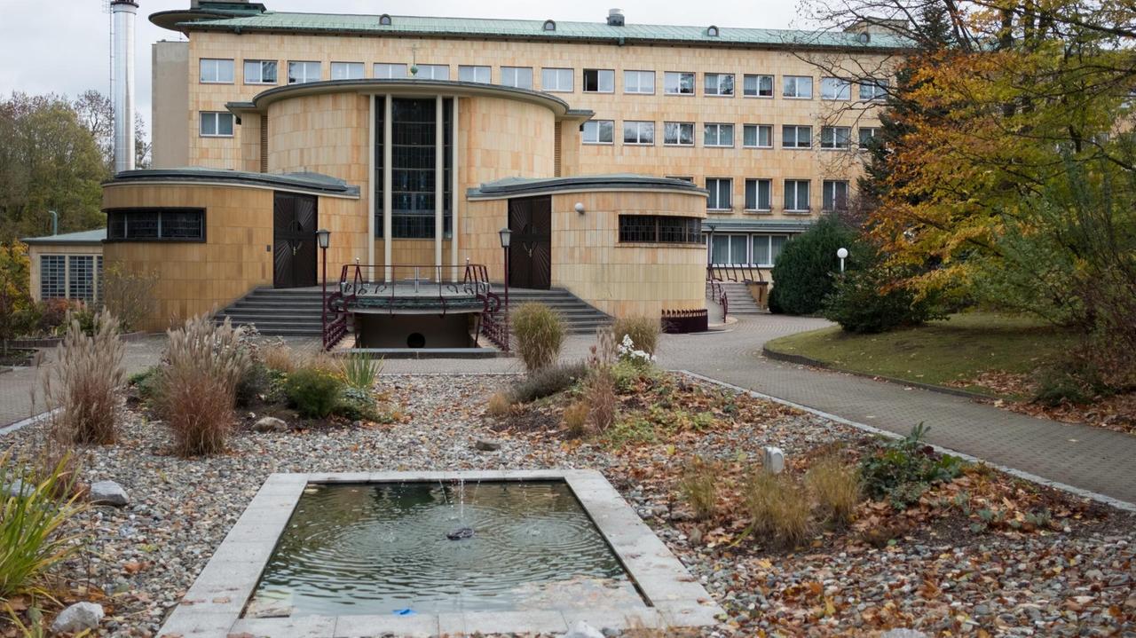 Außenfassade eines Hauses, im Vordergrund ein kleiner Teich Außenfassade eines Hauses, im Vordergrund ein kleiner Teich