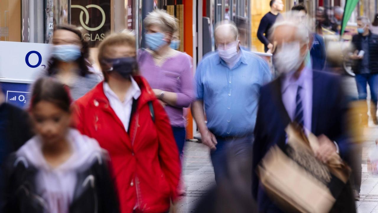 Menschen mit Mund-Nase-Masken in der Fußgängerzone in Köln Menschen mit Mund-Nase-Masken in der Fußgängerzone in Köln