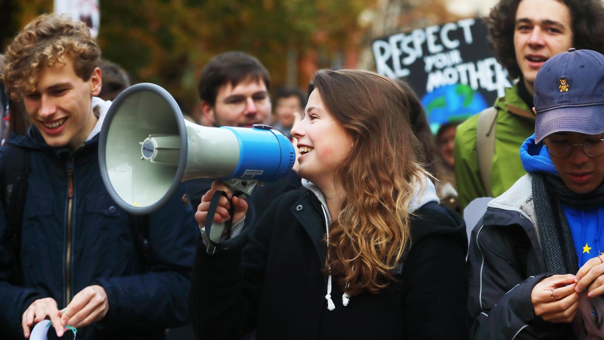 Luisa Neubauer Klimaschutzaktivistin, Autorin und Initiatorin der Berliner Demonstration mit einem Megaphon während des Fußmarsches vom Invalidenpark zum Bundesministerium der Finanzen. Luisa Neubauer Klimaschutzaktivistin, Autorin und Initiatorin der Berliner Demonstration mit einem Megaphon während des Fußmarsches vom Invalidenpark zum Bundesministerium der Finanzen.