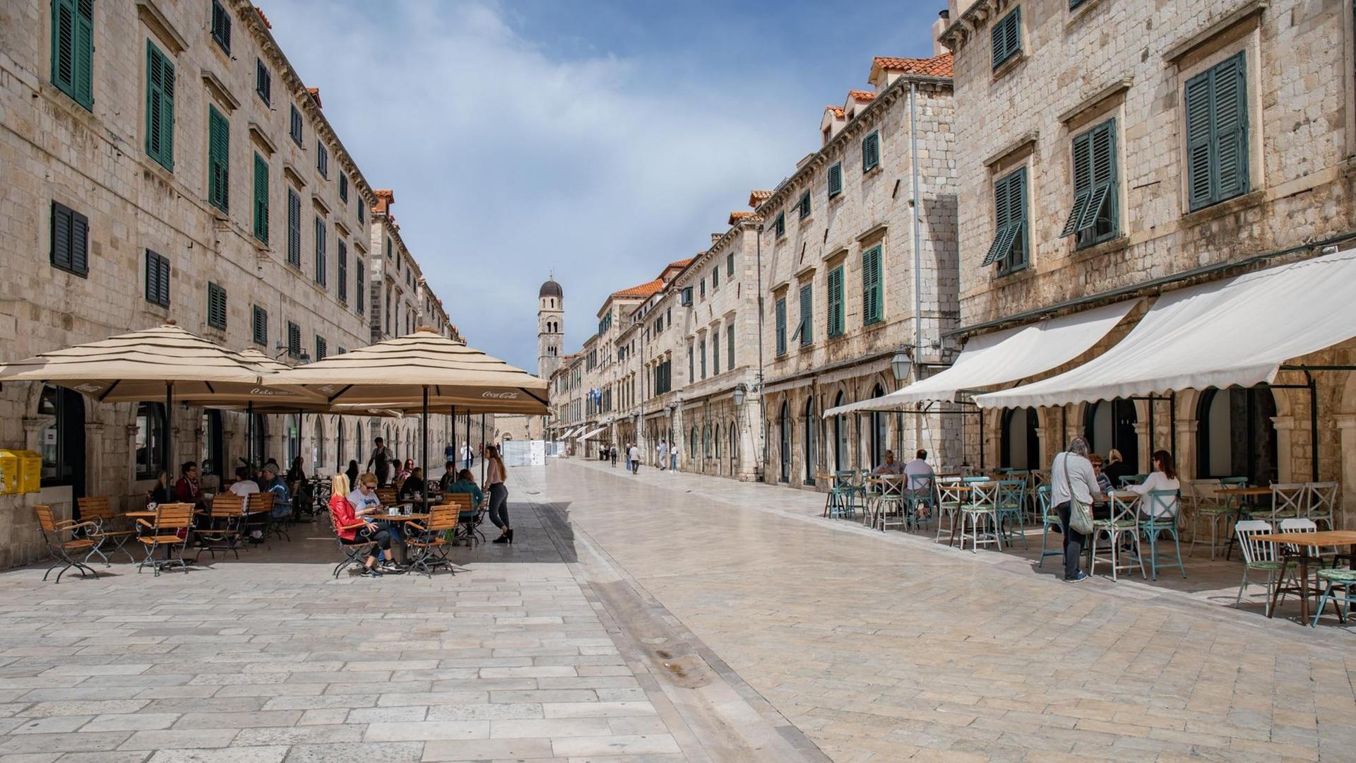 Ein Straßenzug in der Altstadt von Durbovink, recht und links ein Café mit wenigen Besuchern. Ein Straßenzug in der Altstadt von Durbovink, recht und links ein Café mit wenigen Besuchern.