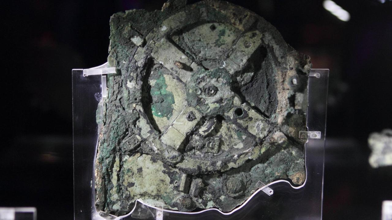 Der Mechanismus von Antikythera, ein nicht mehr funktionierendes, unvollständig erhaltenes Fundstück mit 82 Fragmenten aus der Antike mit einer Vielzahl von Zahnrädern in ähnlicher Anordnung wie in einer Räderuhr, im Archäologischen Nationalmuseum Athen Der Mechanismus von Antikythera, ein nicht mehr funktionierendes, unvollständig erhaltenes Fundstück mit 82 Fragmenten aus der Antike mit einer Vielzahl von Zahnrädern in ähnlicher Anordnung wie in einer Räderuhr, im Archäologischen Nationalmuseum Athen