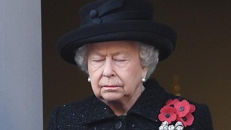 Queen Elizsabeth, mit schwarzem Hut und schwarzer Jacke, hat die Augen geschlossen.