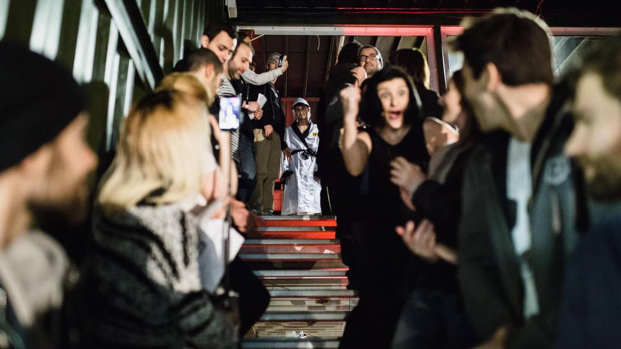 Eine Treppe mit schwarzgekleidetem Publikum, ein Boxer kommt gerade herunter. Eine Treppe mit schwarzgekleidetem Publikum, ein Boxer kommt gerade herunter.