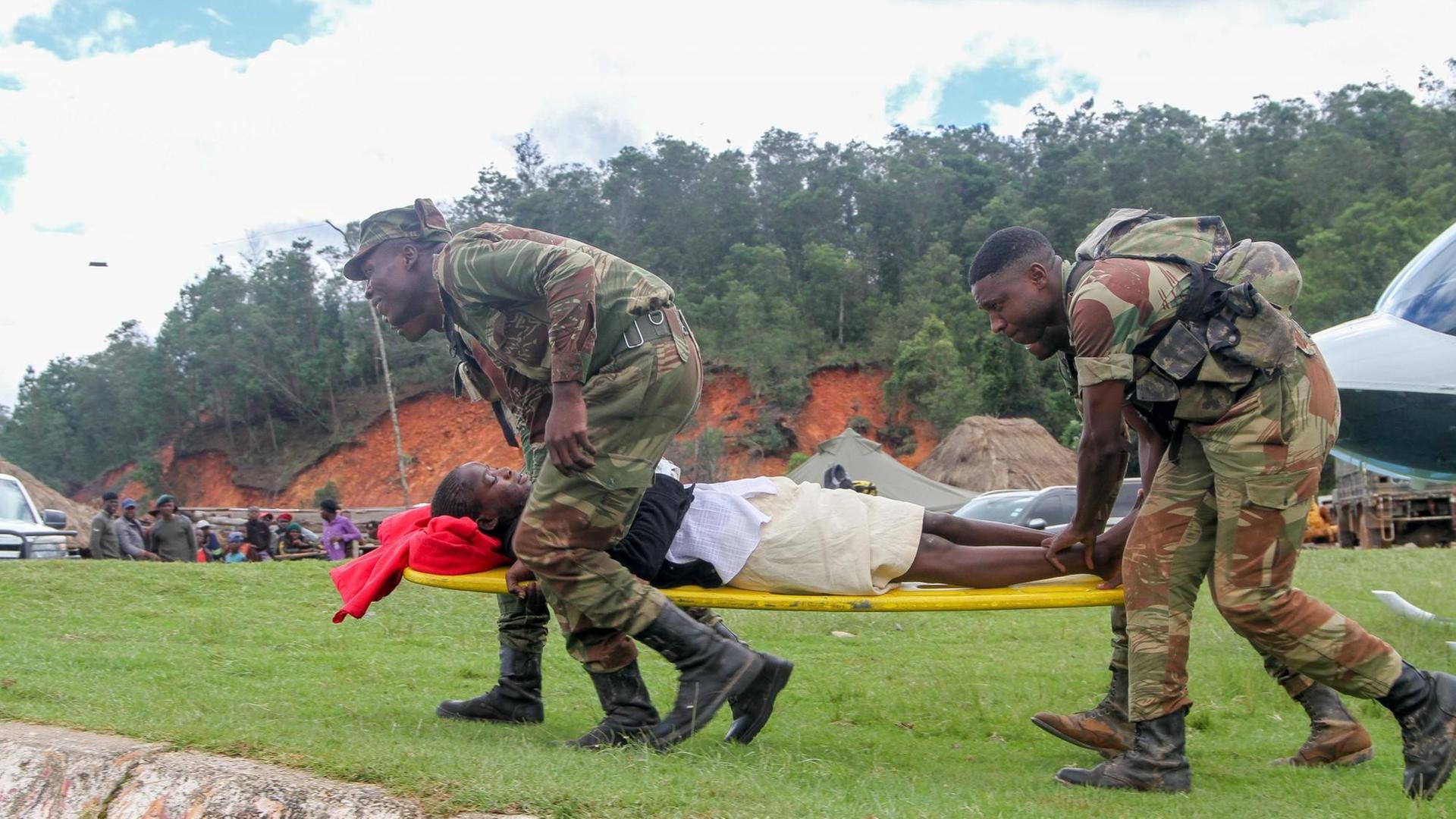 Ein Schwerverletzter wird von Hilfskräften zu einem Hubschrauber gefahren in Chimanimani in Simbabwe am 19. März 2019. Ein Schwerverletzter wird von Hilfskräften zu einem Hubschrauber gefahren in Chimanimani in Simbabwe am 19. März 2019.