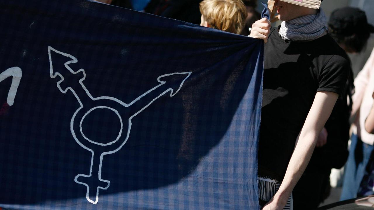 "Normzwang & Psychatrisierung stoppen" steht am Montag (26.03.2012) vor der Senatsverwaltung für Bildung, Jugend und Wissenschaft in Berlin auf einem Schild. Rund 70 Menschen versammelten sich unter dem Motto "Zwangspsychiatrisierung von Alex sofort stoppen!" vor der Behörde um gegen die Zwangseinweisung eines elfjährigen Kinds zu demonstrieren, das entgegen seinem Geburtsgeschlecht als Mädchen leben will. Erst vor wenigen Wochen hatte sich der Ethikrat für eine Anerkennung Intersexueller Menschen ausgesprochen. "Normzwang & Psychatrisierung stoppen" steht am Montag (26.03.2012) vor der Senatsverwaltung für Bildung, Jugend und Wissenschaft in Berlin auf einem Schild. Rund 70 Menschen versammelten sich unter dem Motto "Zwangspsychiatrisierung von Alex sofort stoppen!" vor der Behörde um gegen die Zwangseinweisung eines elfjährigen Kinds zu demonstrieren, das entgegen seinem Geburtsgeschlecht als Mädchen leben will. Erst vor wenigen Wochen hatte sich der Ethikrat für eine Anerkennung Intersexueller Menschen ausgesprochen.