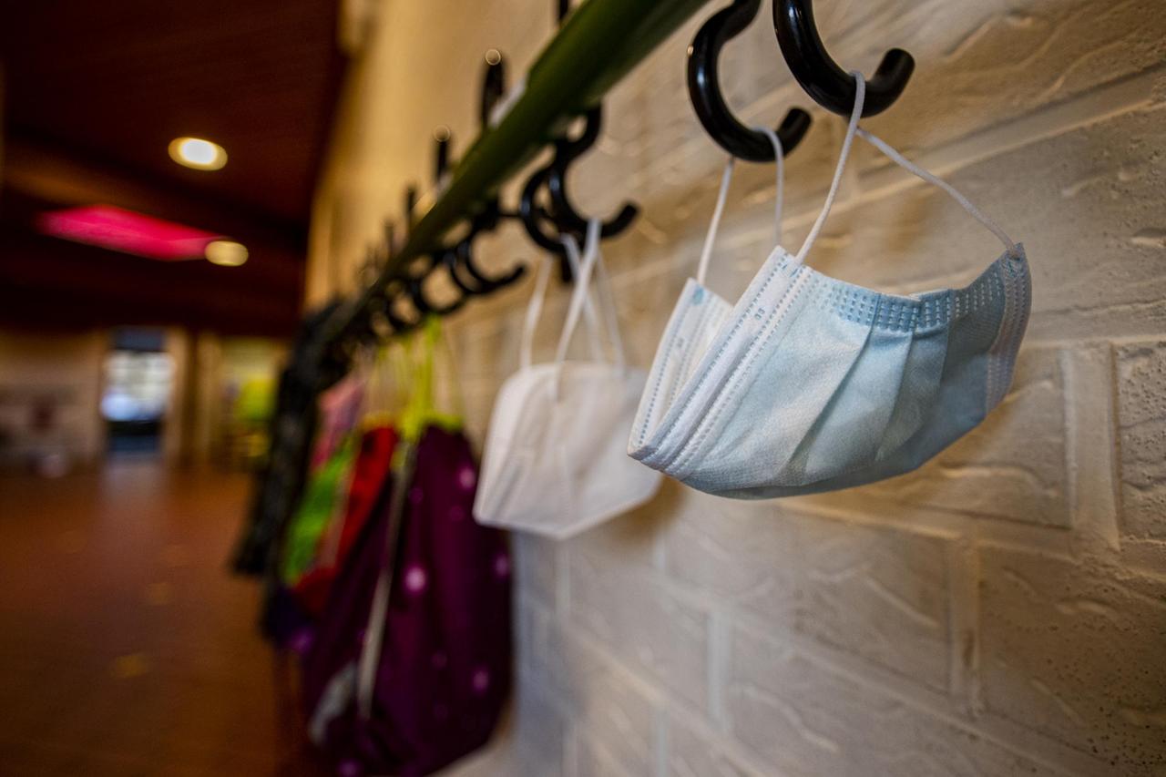 Mundmasken und Jacken hängen im Flur der Schule an einem Kleiderhaken. Die Schulen bleiben während des Corona-Lockdowns geschlossen. Mundmasken und Jacken hängen im Flur der Schule an einem Kleiderhaken. Die Schulen bleiben während des Corona-Lockdowns geschlossen.