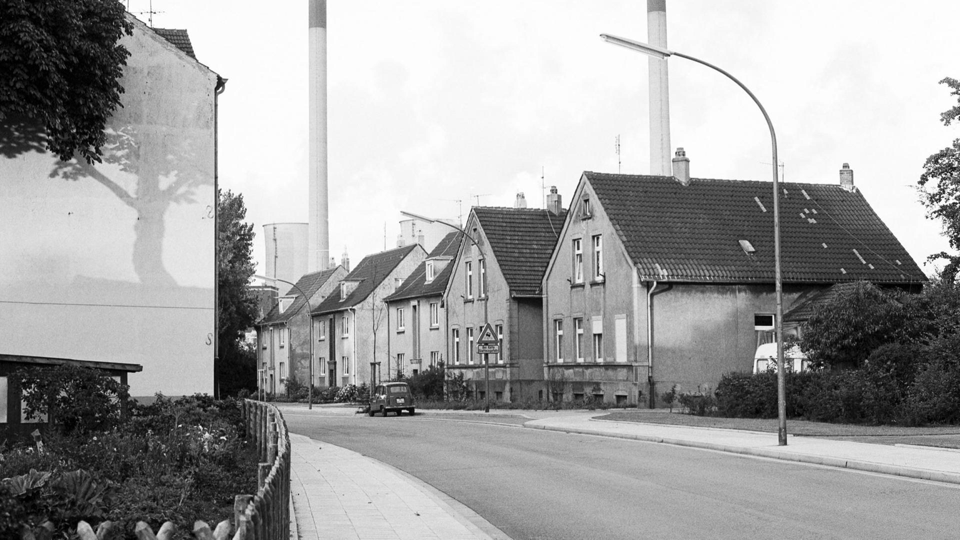 Häuser einer Arbeitersiedlung in Gelsenkirchen in Nordrhein-Westfalen, im Hintergrund Schornsteine einer Fabrik