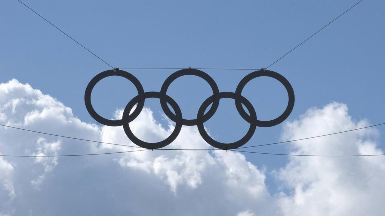 Die olympischen Ringe vor einem blauen Himmel. Im Hintergrund große weiße Wolken. Die olympischen Ringe vor einem blauen Himmel. Im Hintergrund große weiße Wolken.