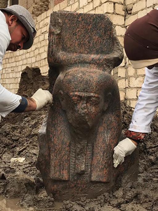 Ein Forschungsteam legt in Ägypten eine Statue von Ramses II. aus rosa Granit frei.