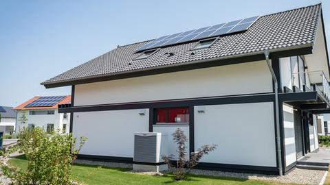 Ein Fertighaus mit Solarzellen für Photovoltaik und einer Luft-Luft-Wärmepumpe in Bayern.