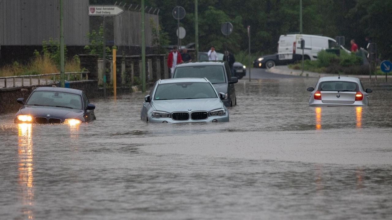 Mehrere Autos stecken nach Starkregen auf einer überfluteten Straße in Stolberg fest.