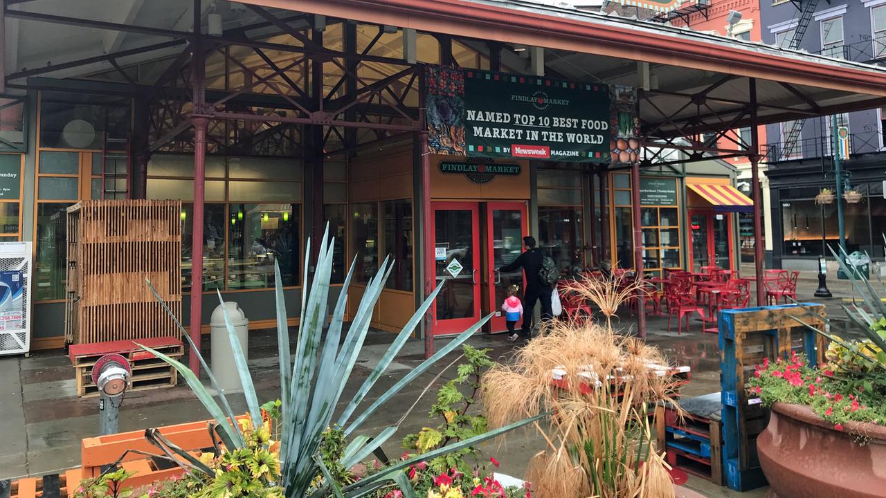 Blick auf eine Markthalle in Cincinnati. Vor dem Eingang sind Planzen aufgestellt, und es gibt Sitzbänke. Blick auf eine Markthalle in Cincinnati. Vor dem Eingang sind Planzen aufgestellt, und es gibt Sitzbänke.