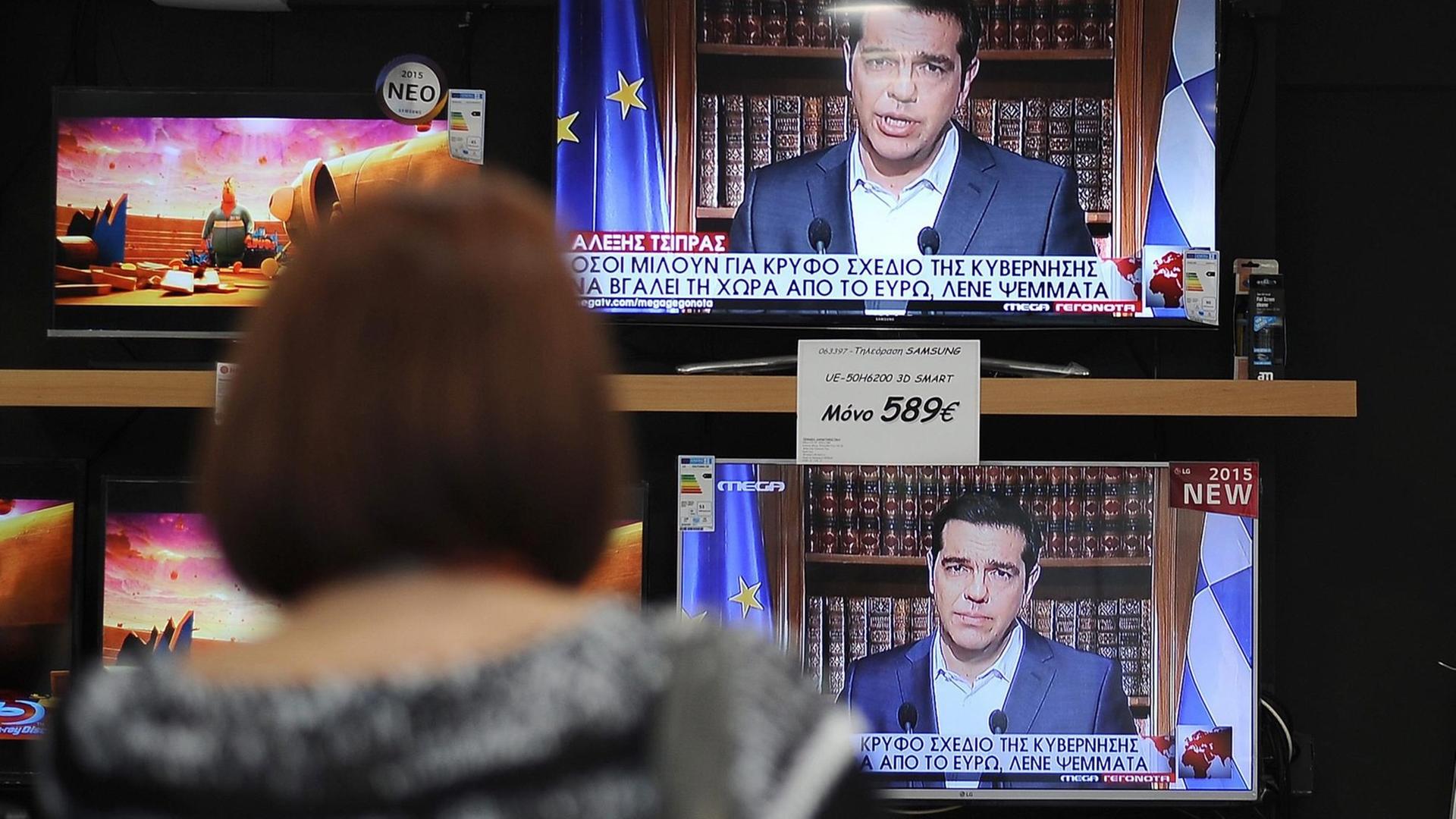 Eine Frau sieht in Athen die Fernsehansprache des griechischen Ministerpräsidenten Alexis Tsipras. Eine Frau sieht in Athen die Fernsehansprache des griechischen Ministerpräsidenten Alexis Tsipras.