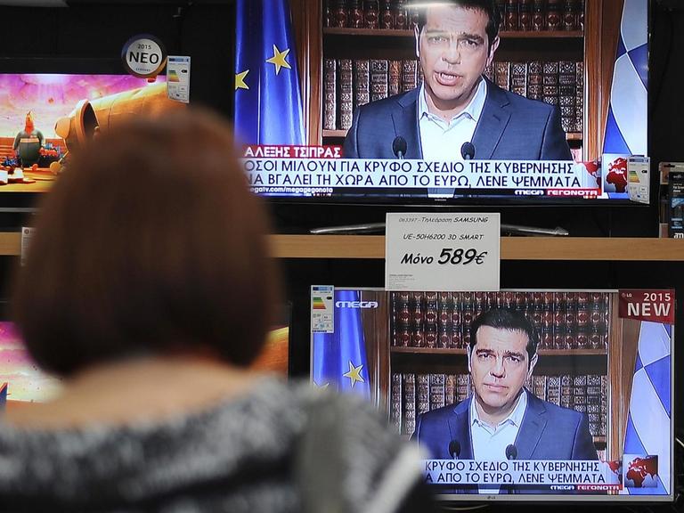 Eine Frau sieht in Athen die Fernsehansprache des griechischen Ministerpräsidenten Alexis Tsipras.