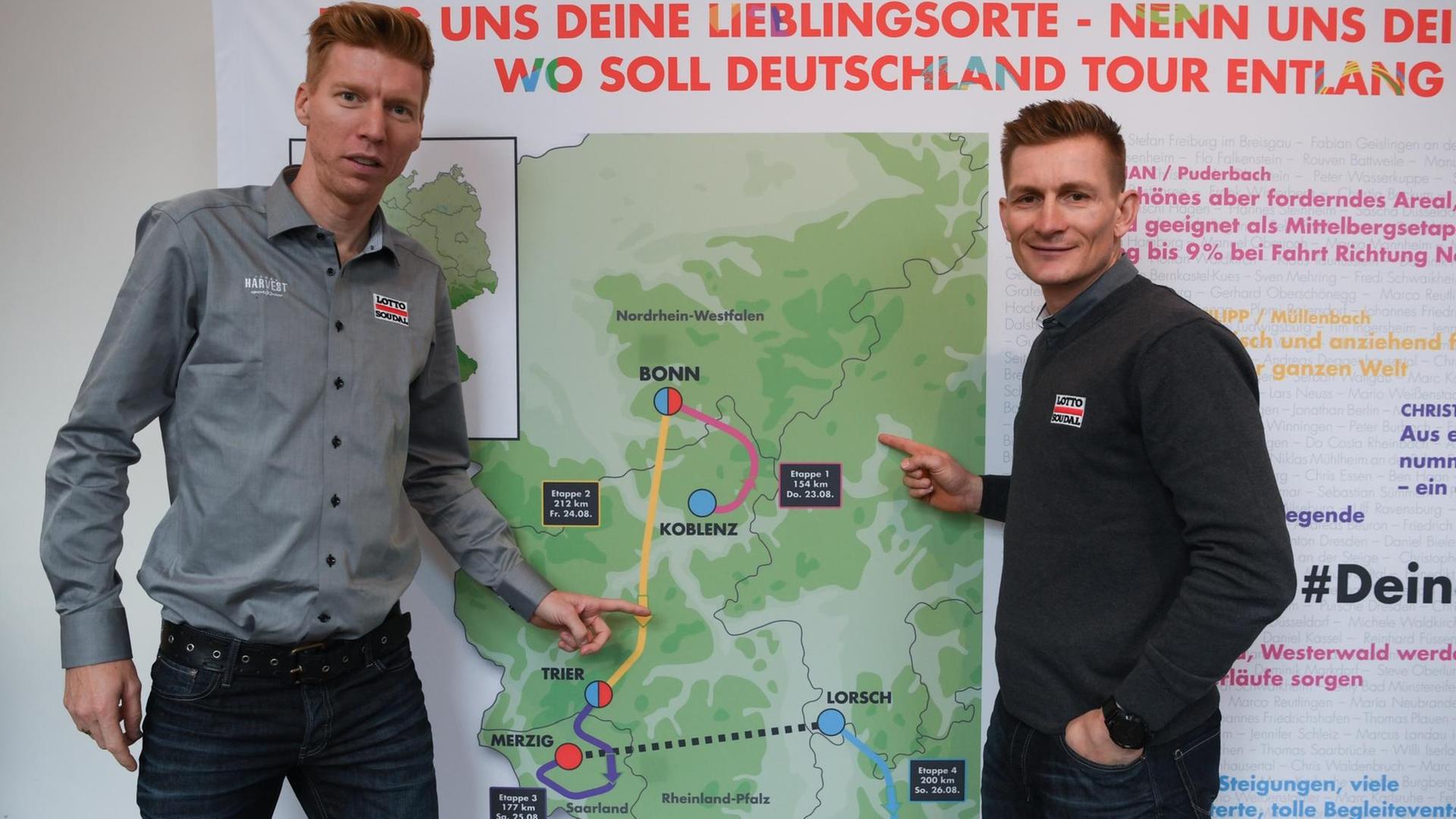 Die beiden Radprofis André Greipel (r.) und Marcel Sieberg vom Team Lotto Soudal zeigen bei der Streckenpräsentation zur Deutschland-Tour 2018 auf die Karte mit den vier Etappen.