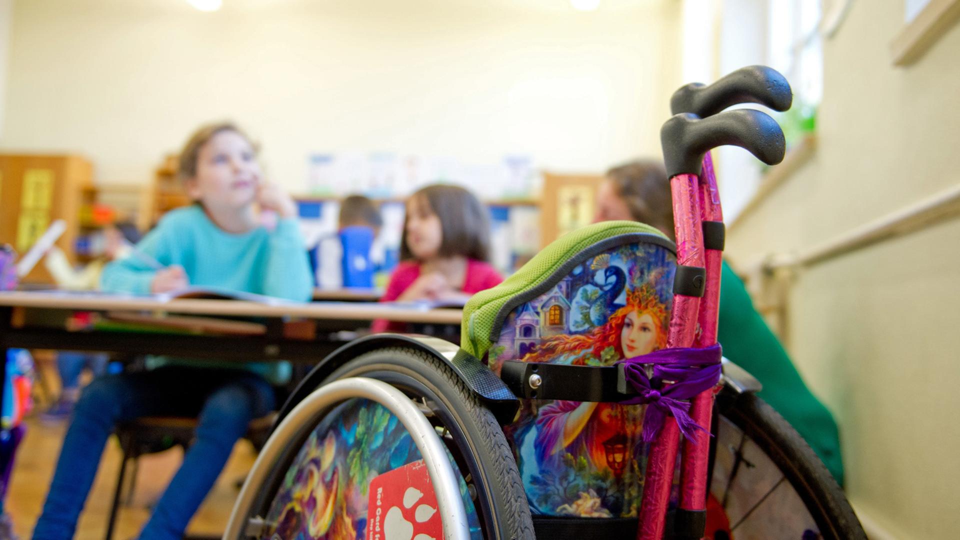 Ein Kinderrollstuhl steht im Klassenzimmer einer Gemeinschaftsgrundschule in Stuttgart. Ein Kinderrollstuhl steht im Klassenzimmer einer Gemeinschaftsgrundschule in Stuttgart.