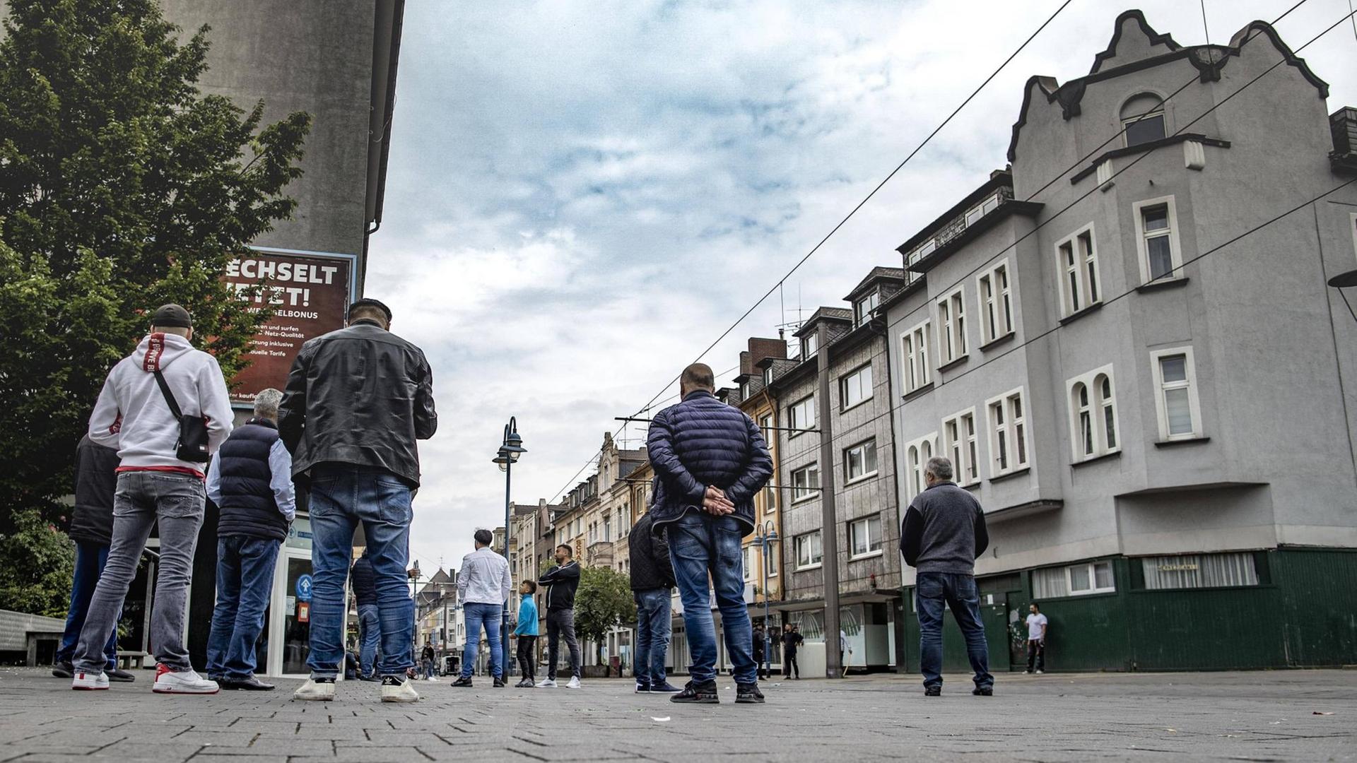 Auf einer gepflasterten Straße in Duisburg-Marxloh stehen einige Männer mit dem Rücken zur Kamera. Auf einer gepflasterten Straße in Duisburg-Marxloh stehen einige Männer mit dem Rücken zur Kamera.
