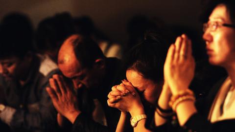 Angehörige der Passagiere des Flugs MH379 beten.