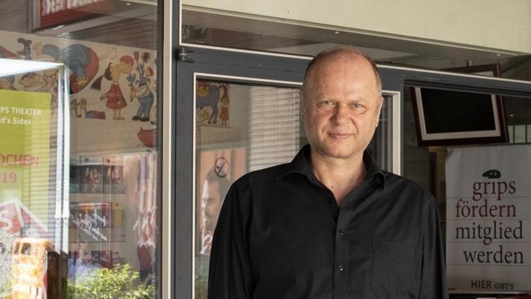 Der Leiter des Grips-Theaters, Philipp Harpain, steht vor dem Eingang seines Theaters und schaut in die Kamera. Der Leiter des Grips-Theaters, Philipp Harpain, steht vor dem Eingang seines Theaters und schaut in die Kamera.