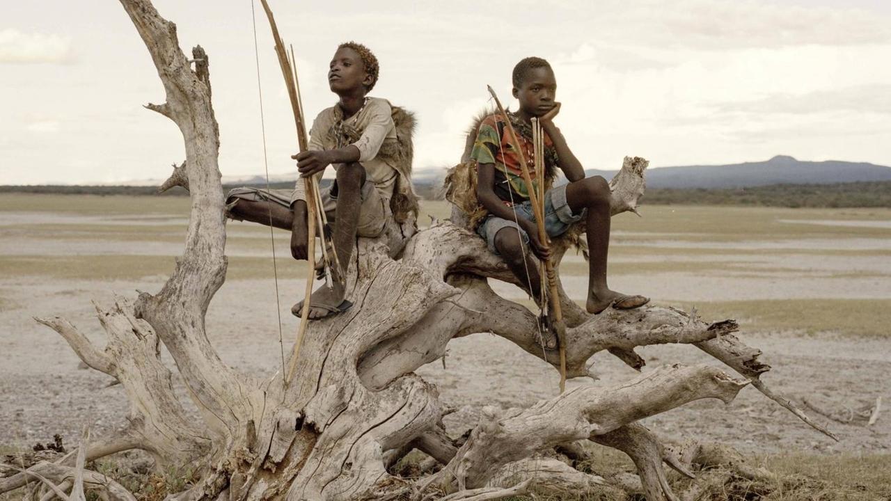 Am Eyasi-See in Tansania halten Osama (15) und Manu (14) Pfeil und Bogen in der Hand, während sie auf einem abgestorbenen Baum sitzen. Sie gehören den Hadza an, einer der letzten Gemeinschaften von Jägern und Sammlern. Am Eyasi-See in Tansania halten Osama (15) und Manu (14) Pfeil und Bogen in der Hand, während sie auf einem abgestorbenen Baum sitzen. Sie gehören den Hadza an, einer der letzten Gemeinschaften von Jägern und Sammlern.
