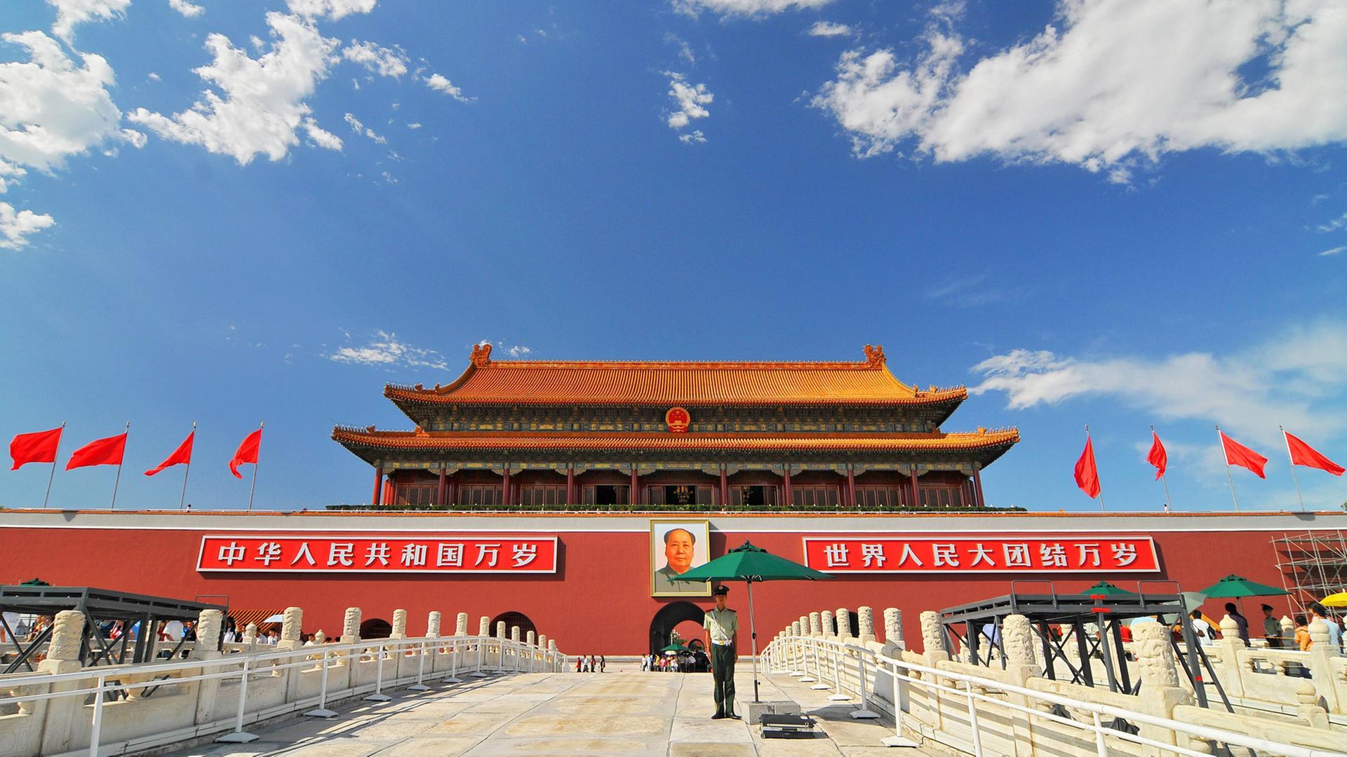 Der Eingang des Königspalasts und der Verbotenen Stadt auf dem Tiananmen-Platz in Peking mit einem Porträt von Mao Zedong und chinesischen Flaggen rechts und links Der Eingang des Königspalasts und der Verbotenen Stadt auf dem Tiananmen-Platz in Peking mit einem Porträt von Mao Zedong und chinesischen Flaggen rechts und links
