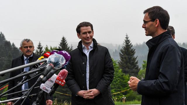 Der österreichische Bundeskanzler Sebastian Kurz (Mitte) steht bei seinem besuch im Kleinwalsertal am 13.05.2020 neben Andi Haid, Bürgermeister Mittelberg (links), und Markus Wallner, Landeshauptmann Vorarlberg (rechts), während zahlreiche Mikrofone von Medienvertretern auf ihn gerichtet sind. Der österreichische Bundeskanzler Sebastian Kurz (Mitte) steht bei seinem besuch im Kleinwalsertal am 13.05.2020 neben Andi Haid, Bürgermeister Mittelberg (links), und Markus Wallner, Landeshauptmann Vorarlberg (rechts), während zahlreiche Mikrofone von Medienvertretern auf ihn gerichtet sind.