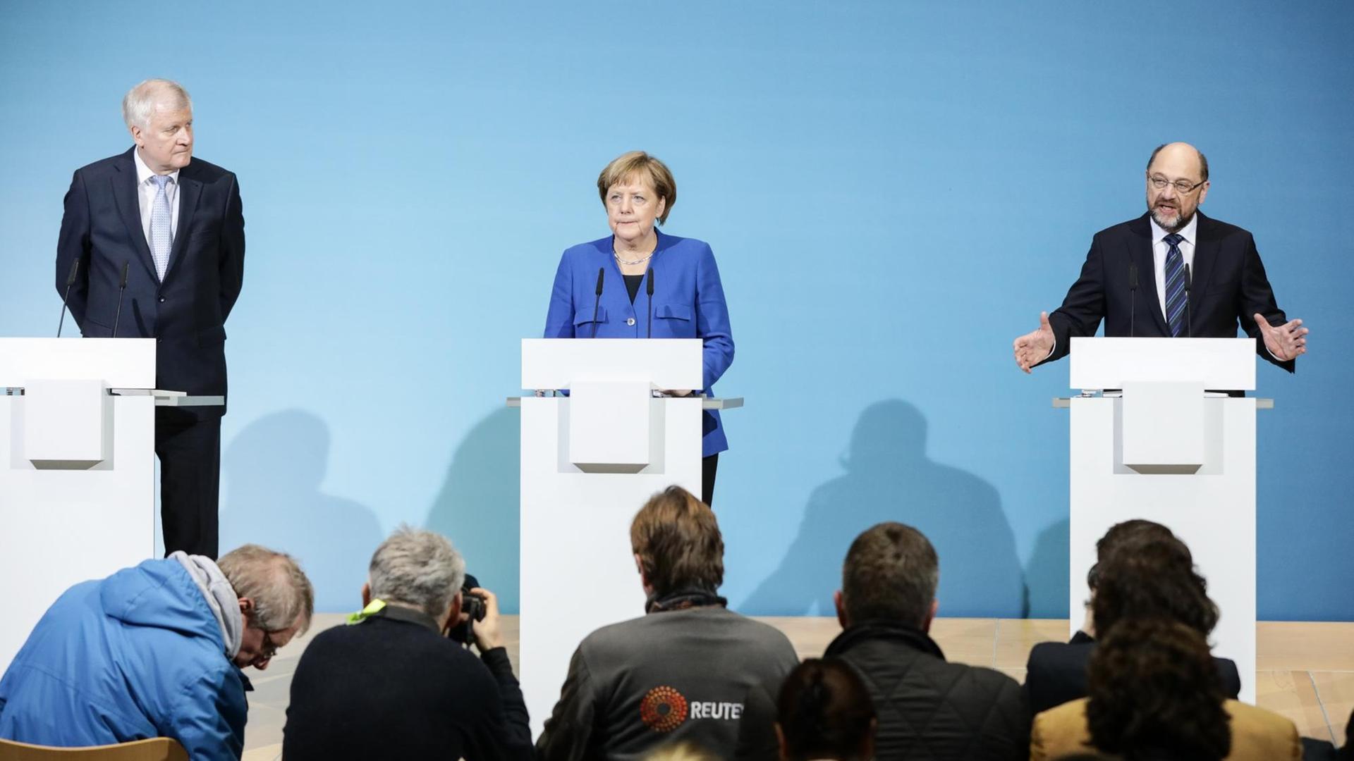 Der CSU-Vorsitzenden Horst Seehofer (l), der SPD-Parteivorsitzende Martin Schulz (r) und Bundeskanzlerin Angela Merkel (CDU) stehen im Berliner Willy-Brandt-Haus nebeneinander an Redepulten. Der CSU-Vorsitzenden Horst Seehofer (l), der SPD-Parteivorsitzende Martin Schulz (r) und Bundeskanzlerin Angela Merkel (CDU) stehen im Berliner Willy-Brandt-Haus nebeneinander an Redepulten.