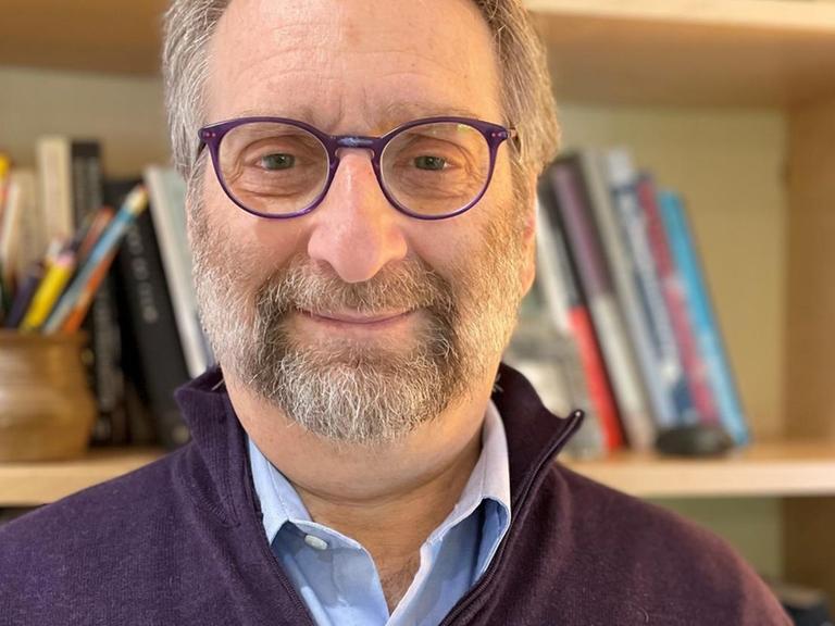 Porträtfoto von Edward Larkey vor einem Bücherregal