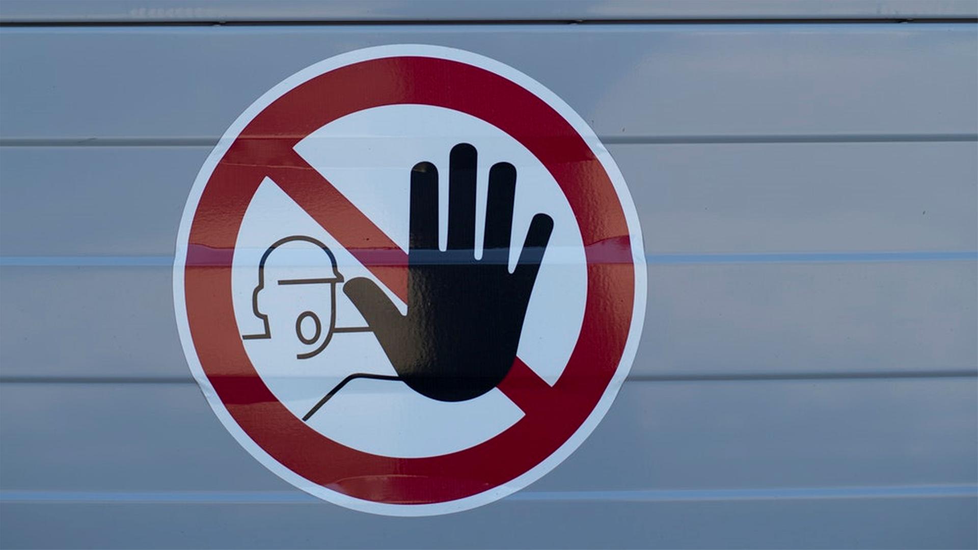 Aufkleber eines unkonventionellen Stopp-Schildes. Zu sehen ist das Piktogramm eines Mann der eine große schwarze Hand nach vorn hält. Aufkleber eines unkonventionellen Stopp-Schildes. Zu sehen ist das Piktogramm eines Mann der eine große schwarze Hand nach vorn hält.