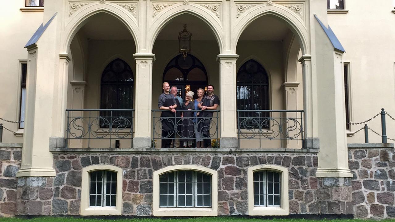 Jan Henrik Eilers und dessen Eltern stehen mit dem restlichen Team vom Schlosshotel Reichenow auf einem Balkon. Jan Henrik Eilers und dessen Eltern stehen mit dem restlichen Team vom Schlosshotel Reichenow auf einem Balkon.