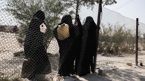 Syrien / al-Hawl Camp /// Frauen im al-Hawl Camp betteln am Zaun nach Brennmitteln, die sie zum Kochen benutzten. Das al-Hawl Camp, hier die Abteilung für Frauen und Kinder aus überwiegend europäischen und russischen Gebieten, liegt zwischen al-Hasska und der irakischen Grenze. Hier sind etwa 72.000 Menschen untergebracht, die vormals in den syrischen Gebieten des sogenannten "Islamischen Staates" lebten.