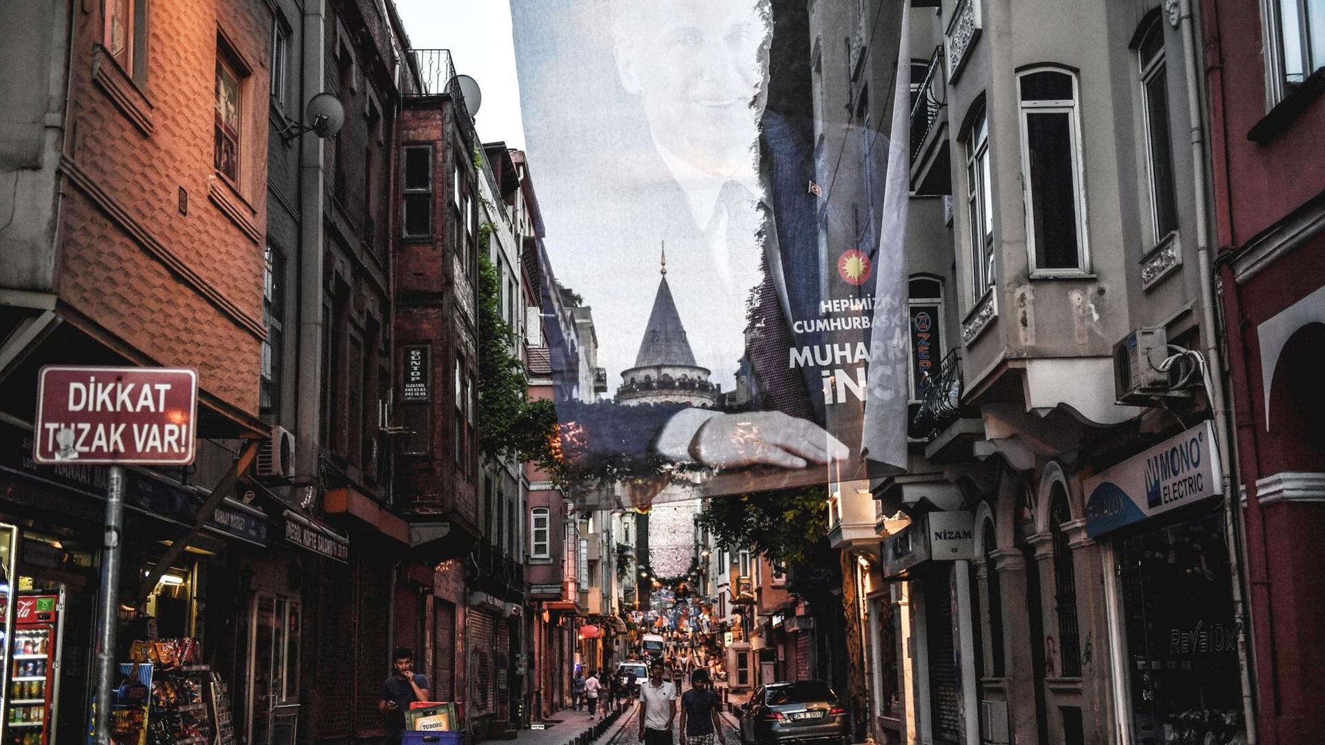 Spaziergänger unter einem Wahlplakat des Präsidentschaftskandidaten Muharrem Ince im Künstlerviertel Beyoglu, Istanbul, Juni 2018 Spaziergänger unter einem Wahlplakat des Präsidentschaftskandidaten Muharrem Ince im Künstlerviertel Beyoglu, Istanbul, Juni 2018