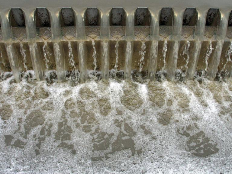 Wasseraufbereitung im Klärwerk in Zweibrücken: Im Vorklärbecken setzen sich die organischen Schlämme ab, danach fließt das Wasser über eine Zahnschwelle.