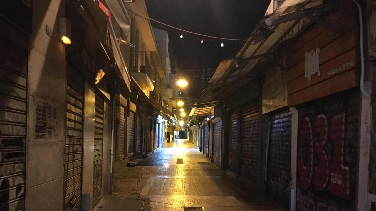 Blick in eine leere und dunkle Straße im Ausgeh-Viertel Plaka in Athen. 