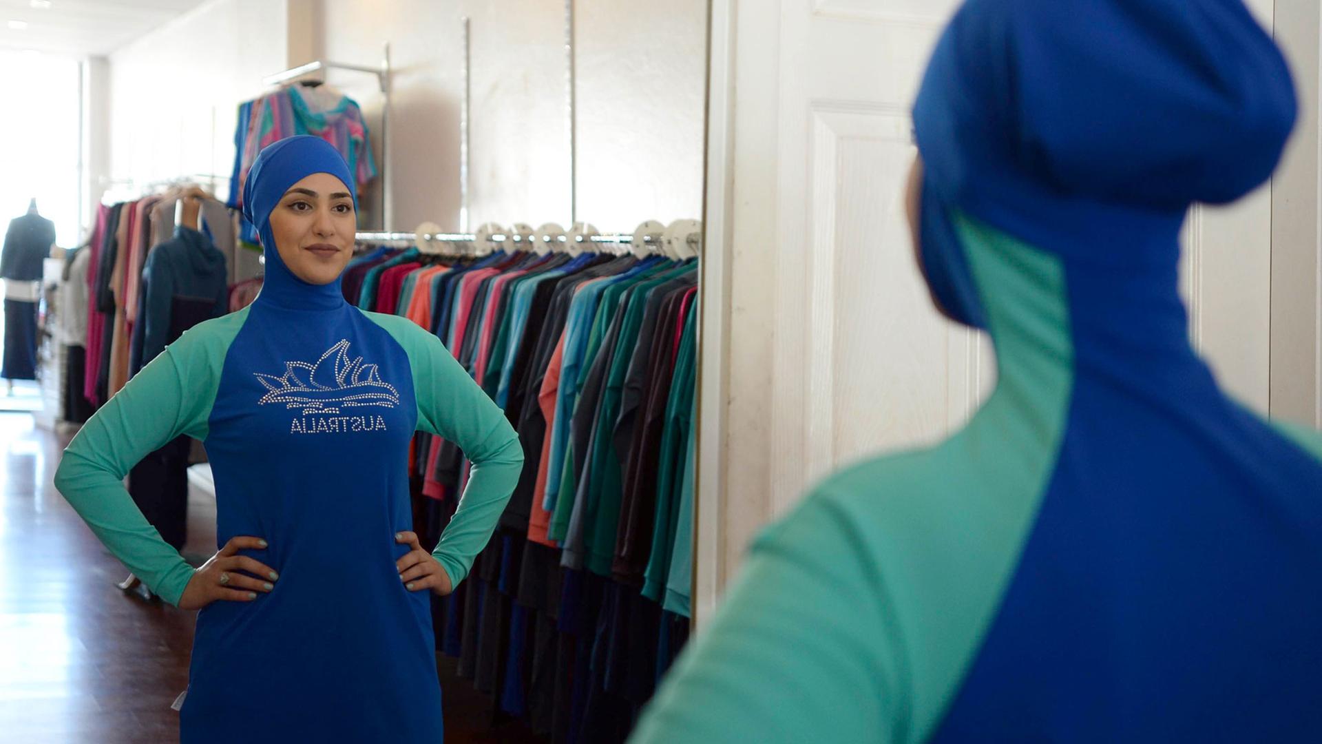 Eine Frau posiert in einem Burkini in einem Geschäft. Eine Frau posiert in einem Burkini in einem Geschäft.