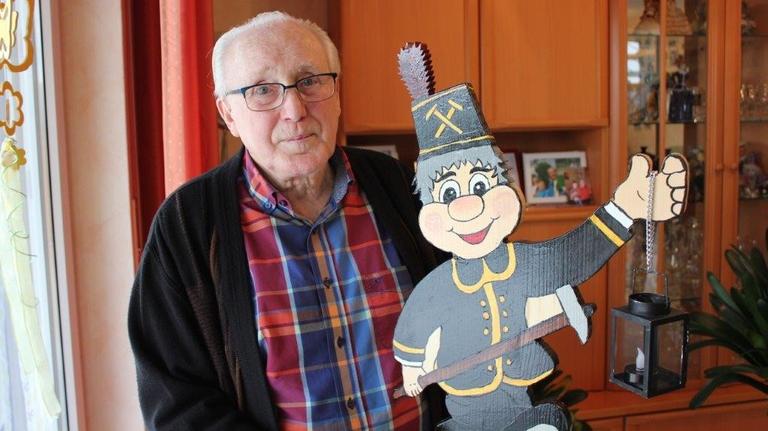 Ex-Bergmann Josef Grötte hält eine hölzerne Bergmannsfigur. Ex-Bergmann Josef Grötte hält eine hölzerne Bergmannsfigur.